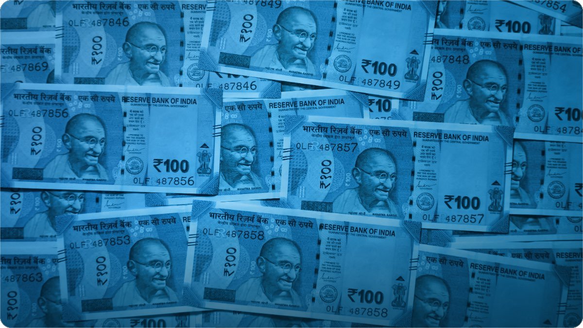 Bundles of South Asian rupee notes stacked in rows.